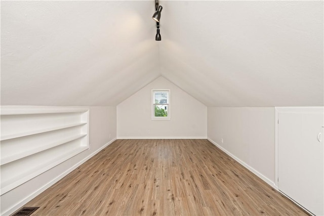 131 Pomona Dr, Greece, NY 14616 - bonus room featuring light wood-style floors, lofted ceiling, baseboards, and built in shelves