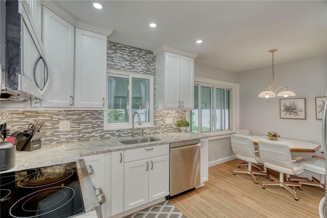 261 Hager Rd, Greece, NY 14616 - kitchen with stainless steel appliances, a sink, backsplash, white cabinetry, and light wood-type flooring