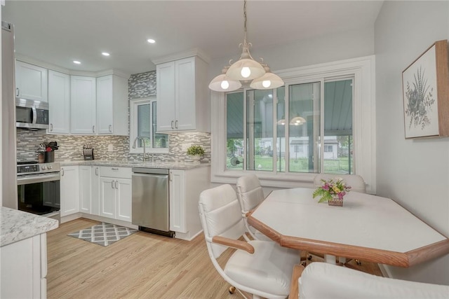 261 Hager Rd, Greece, NY 14616 - kitchen with appliances with stainless steel finishes, light wood finished floors, backsplash, and recessed lighting