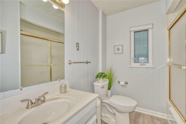 261 Hager Rd, Greece, NY 14616 - bathroom with vanity, toilet, wood finished floors, combined bath / shower with glass door, and a textured ceiling
