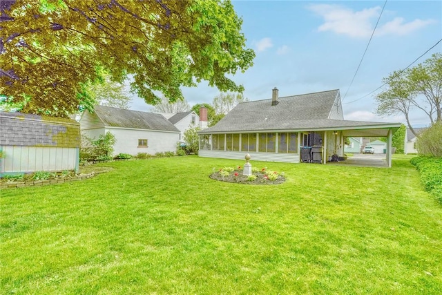 261 Hager Rd, Greece, NY 14616 - rear view of property with a sunroom, a lawn, an attached carport, and a chimney