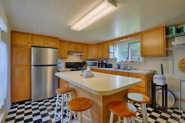 3180 Carleton Island Rd Unit 1, Cape Vincent, NY 13618 - kitchen featuring freestanding refrigerator, tile patterned floors, black stove, under cabinet range hood, and wooden ceiling