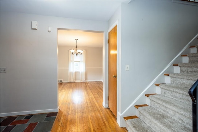 1711 N Winton Rd, Irondequoit, NY 14609 - stairs featuring a chandelier, baseboards, and wood finished floors