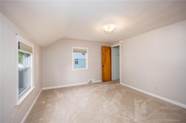 1711 N Winton Rd, Irondequoit, NY 14609 - unfurnished bedroom featuring light colored carpet, vaulted ceiling, baseboards, and a closet