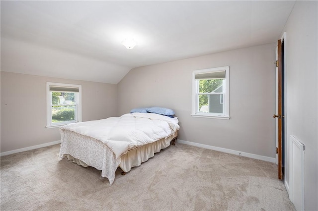 1711 N Winton Rd, Irondequoit, NY 14609 - bedroom featuring multiple windows, light carpet, vaulted ceiling, and baseboards