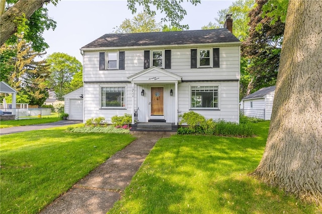 1711 N Winton Rd, Irondequoit, NY 14609 - colonial house featuring a chimney, a front lawn, a garage, and asphalt driveway