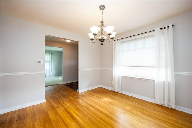 1711 N Winton Rd, Irondequoit, NY 14609 - unfurnished room featuring a chandelier, light wood-style floors, and baseboards