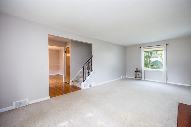1711 N Winton Rd, Irondequoit, NY 14609 - carpeted empty room featuring stairway and baseboards