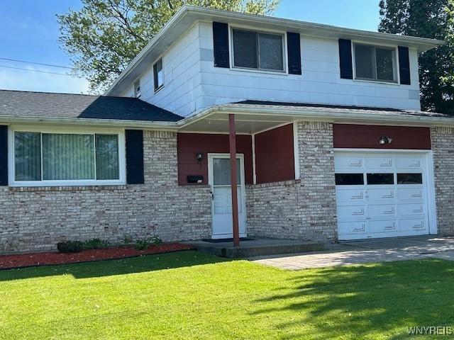 5 Saint Joan Ln, Cheektowaga, NY 14227 - view of front of home with brick siding, an attached garage, and a front yard