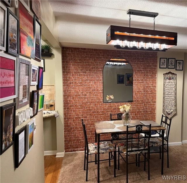 4547 Chestnut Ridge Rd Unit 104B, Amherst, NY 14228 - dining area with brick wall, baseboards, and a textured ceiling