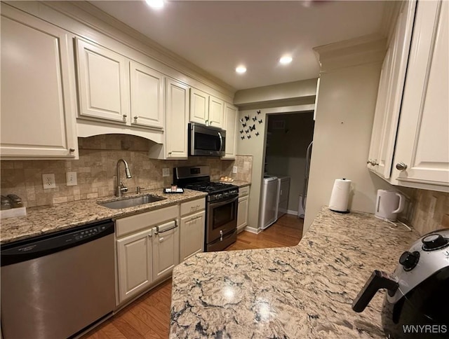 4547 Chestnut Ridge Rd Unit 104B, Amherst, NY 14228 - kitchen with stainless steel appliances, a sink, separate washer and dryer, light wood-style flooring, and white cabinets