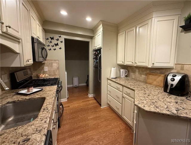 4547 Chestnut Ridge Rd Unit 104B, Amherst, NY 14228 - kitchen with appliances with stainless steel finishes, white cabinets, a sink, decorative backsplash, and recessed lighting