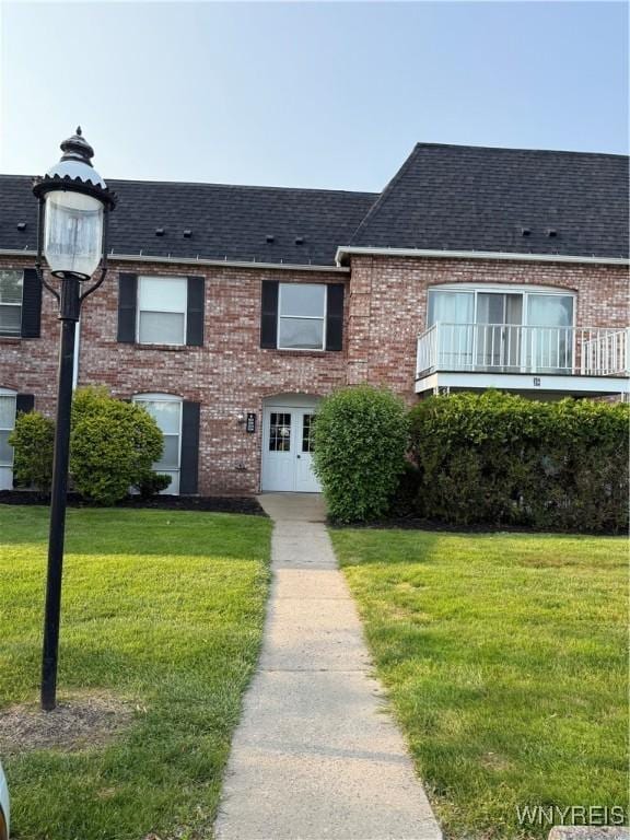 4547 Chestnut Ridge Rd Unit 104B, Amherst, NY 14228 - view of front of house featuring brick siding, roof with shingles, and a front lawn