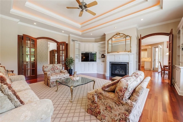 1814 Trellis Cir, Webster, NY 14580 - living area with arched walkways, a raised ceiling, ceiling fan, light wood-type flooring, and a fireplace