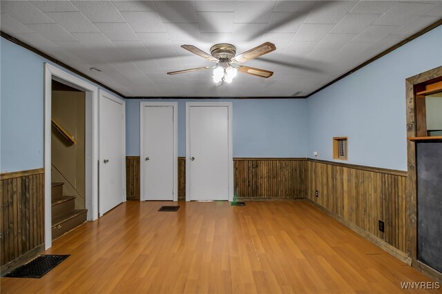 6305 E Main St, Byron, NY 14557 - unfurnished bedroom with a wainscoted wall, light wood finished floors, and wood walls