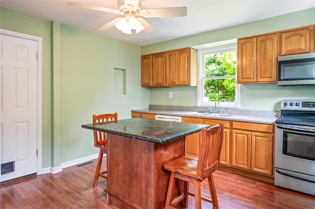 86 Leonard Rd, Greece, NY 14616 - kitchen with appliances with stainless steel finishes, a sink, a kitchen bar, and dark wood-style floors