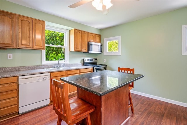86 Leonard Rd, Greece, NY 14616 - kitchen with appliances with stainless steel finishes, a sink, a breakfast bar, and dark wood-style flooring