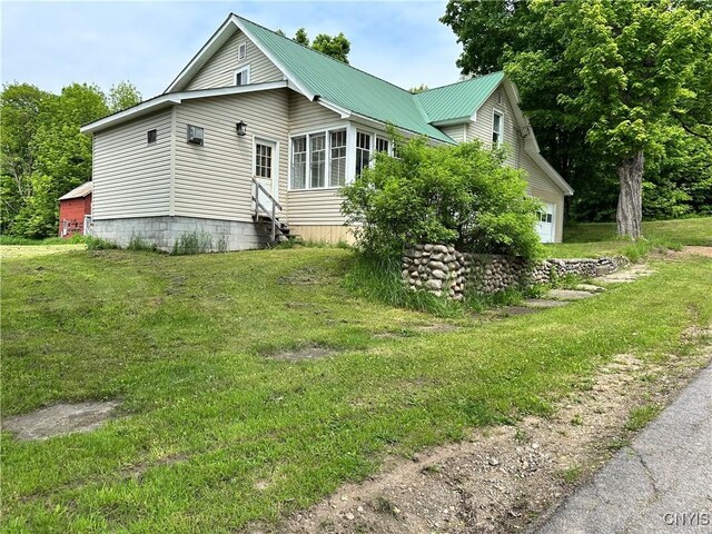 21 Church St, Fine, NY 13617 - view of home's exterior featuring entry steps, a lawn, and metal roof