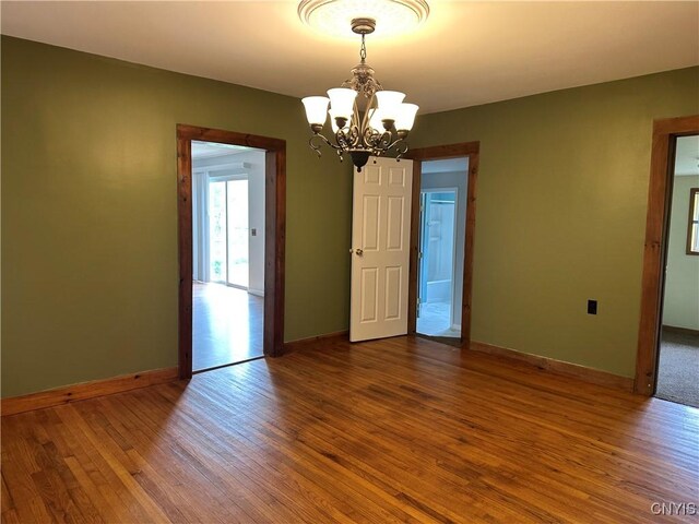 21 Church St, Fine, NY 13617 - unfurnished room with a chandelier, wood finished floors, and baseboards