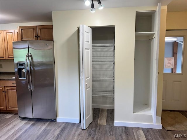 21 Church St, Fine, NY 13617 - kitchen with stainless steel refrigerator with ice dispenser, wood finished floors, dark countertops, and brown cabinetry