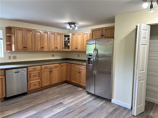21 Church St, Fine, NY 13617 - kitchen with appliances with stainless steel finishes, brown cabinetry, dark countertops, open shelves, and dark wood-style flooring
