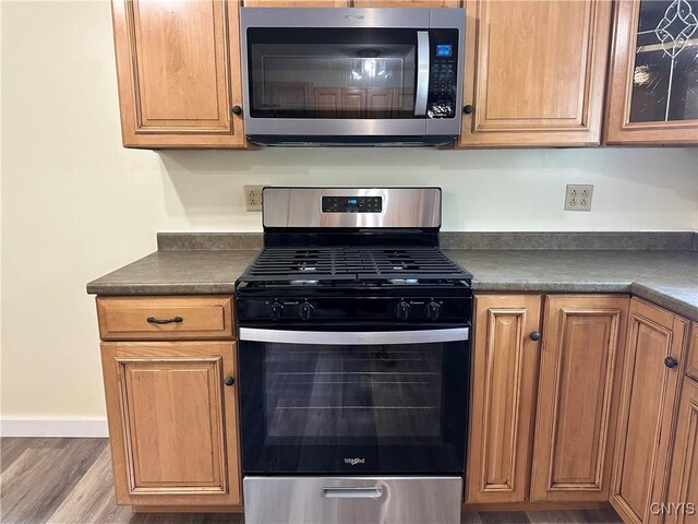 21 Church St, Fine, NY 13617 - kitchen featuring stainless steel appliances, dark countertops, wood finished floors, and brown cabinets