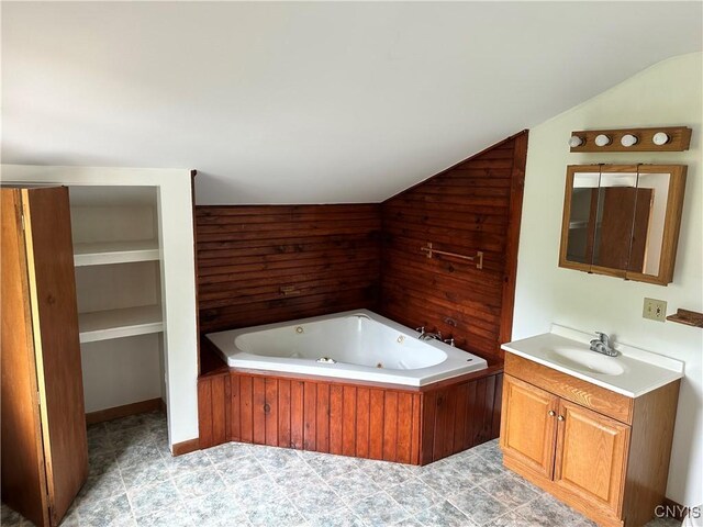 21 Church St, Fine, NY 13617 - bathroom featuring vanity, lofted ceiling, a jetted tub, and wood walls