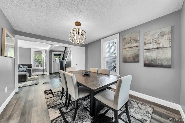 355 Bryant St, North Tonawanda, NY 14120 - dining area with stairs, a textured ceiling, wood finished floors, a chandelier, and baseboards