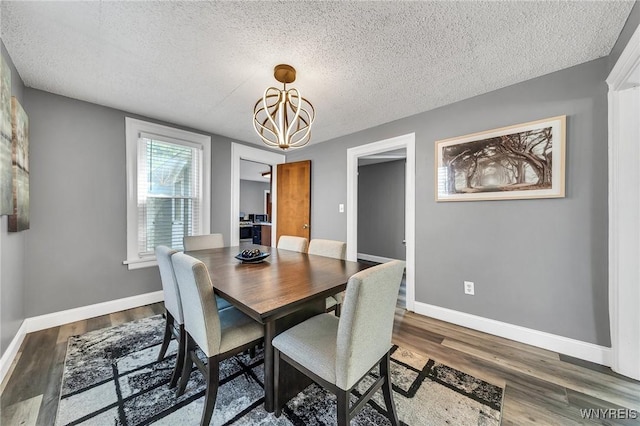 355 Bryant St, North Tonawanda, NY 14120 - dining room featuring a textured ceiling, a chandelier, wood finished floors, and baseboards