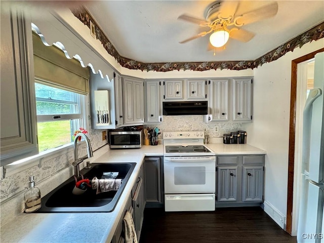 5812 S Street Rd, Fleming, NY 13021 - kitchen with white appliances, under cabinet range hood, gray cabinets, a sink, and light countertops