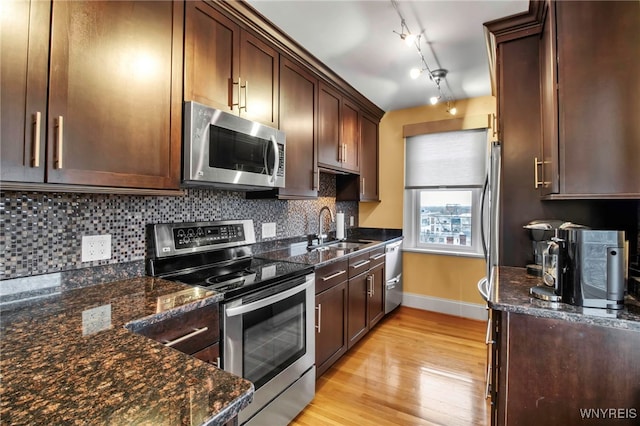 83 Bryant St Unit 7D, Buffalo, NY 14209 - kitchen featuring stainless steel appliances, baseboards, a sink, light wood finished floors, and backsplash