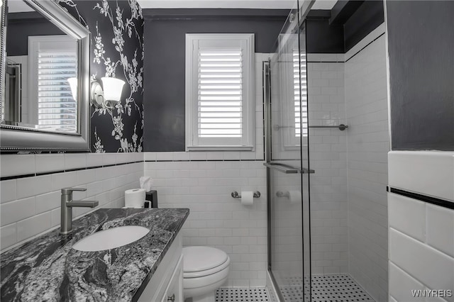 83 Bryant St Unit 7D, Buffalo, NY 14209 - bathroom with wallpapered walls, a stall shower, vanity, wainscoting, and toilet