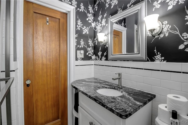 83 Bryant St Unit 7D, Buffalo, NY 14209 - half bath with tile walls, wallpapered walls, vanity, toilet, and a wainscoted wall