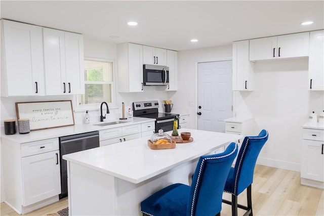 136 Nevins Rd, Henrietta, NY 14467 - kitchen featuring appliances with stainless steel finishes, a sink, light wood finished floors, a breakfast bar area, and recessed lighting