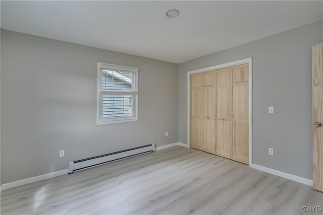 34292 State Route 26, Champion, NY 13619 - unfurnished bedroom featuring baseboard heating, wood finished floors, a closet, and baseboards