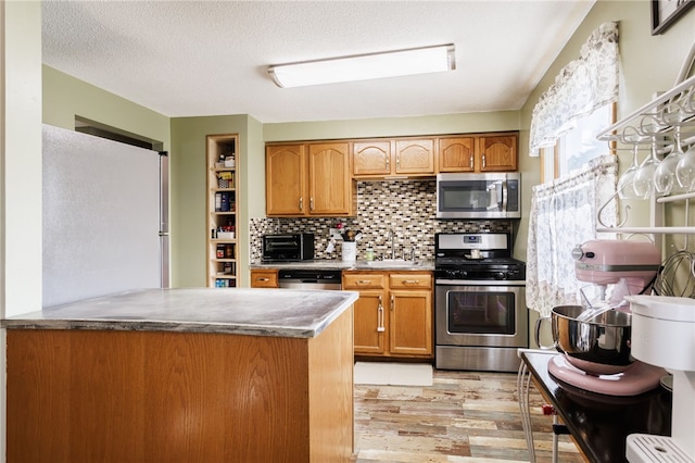 44 Hidden Creek Ln, Hamlin, NY 14464 - kitchen with stainless steel appliances, light wood-type flooring, a sink, brown cabinets, and a textured ceiling