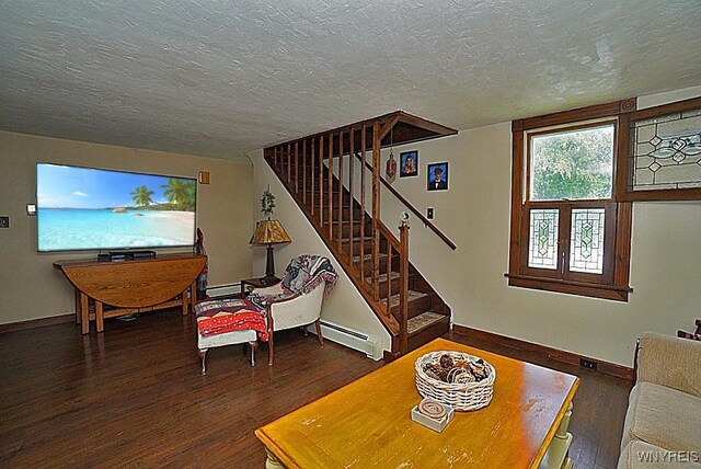 2477 Ridge Rd, Lewiston, NY 14131 - living room with a baseboard heating unit, wood finished floors, a textured ceiling, stairs, and baseboards