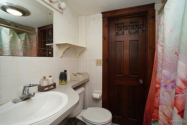 2477 Ridge Rd, Lewiston, NY 14131 - bathroom with a sink, tile walls, toilet, and a shower with shower curtain