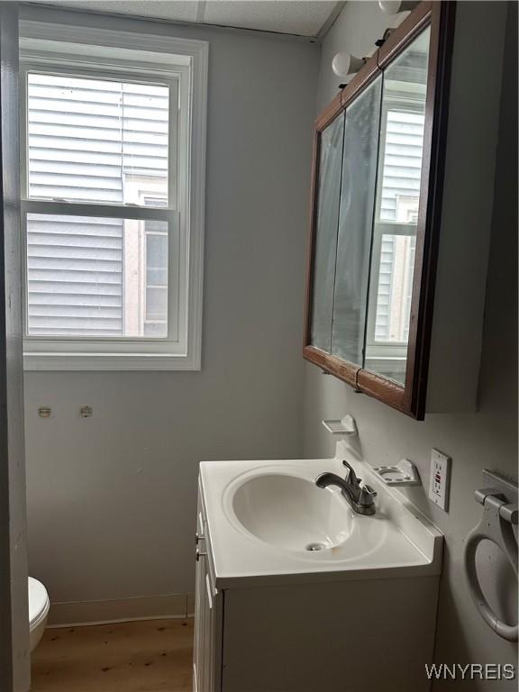 64 Barton St, Buffalo, NY 14213 - bathroom featuring toilet, wood finished floors, vanity, and baseboards