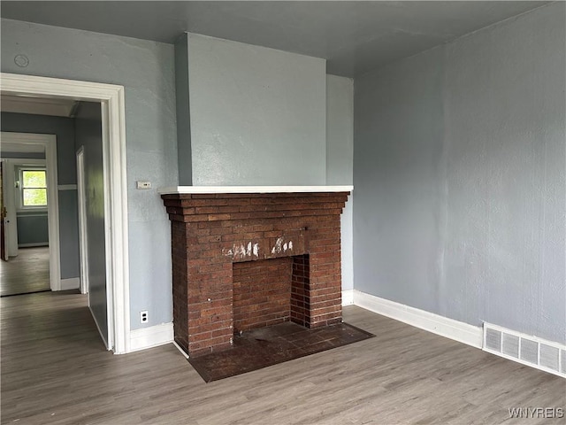 64 Barton St, Buffalo, NY 14213 - unfurnished living room with wood finished floors, baseboards, and a brick fireplace