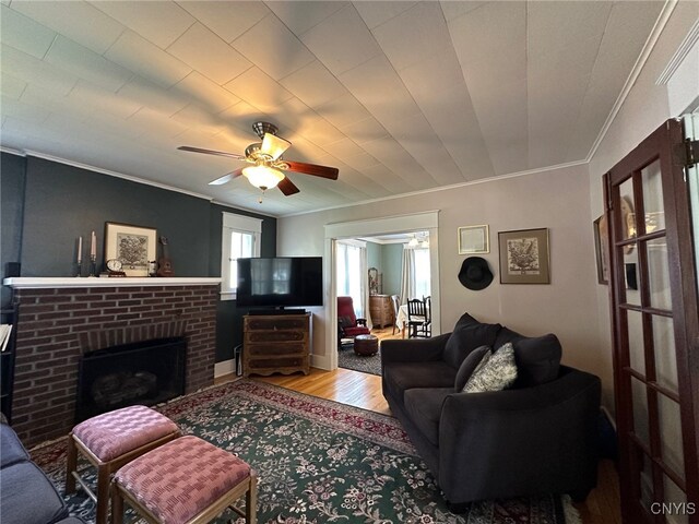 616 N Main St, Herkimer, NY 13350 - living room with crown molding, ceiling fan, wood finished floors, and a brick fireplace