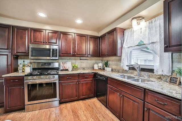 305 Vine Ln, Amherst, NY 14228 - kitchen featuring appliances with stainless steel finishes, a sink, light wood-style flooring, backsplash, and light stone counters