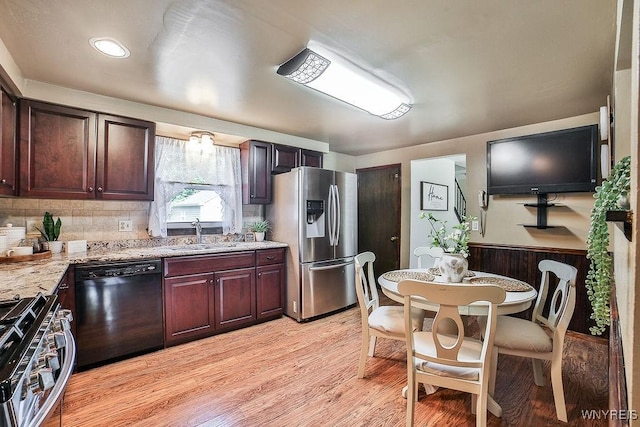 305 Vine Ln, Amherst, NY 14228 - kitchen featuring appliances with stainless steel finishes, light wood-style floors, a sink, tasteful backsplash, and light stone countertops