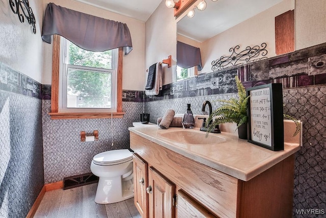 305 Vine Ln, Amherst, NY 14228 - bathroom featuring healthy amount of natural light, vanity, toilet, wood finished floors, and a wainscoted wall