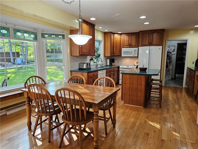 52 Woodland Dr, Big Flats, NY 14814 - kitchen with white appliances, dark countertops, light wood finished floors, brown cabinets, and tasteful backsplash