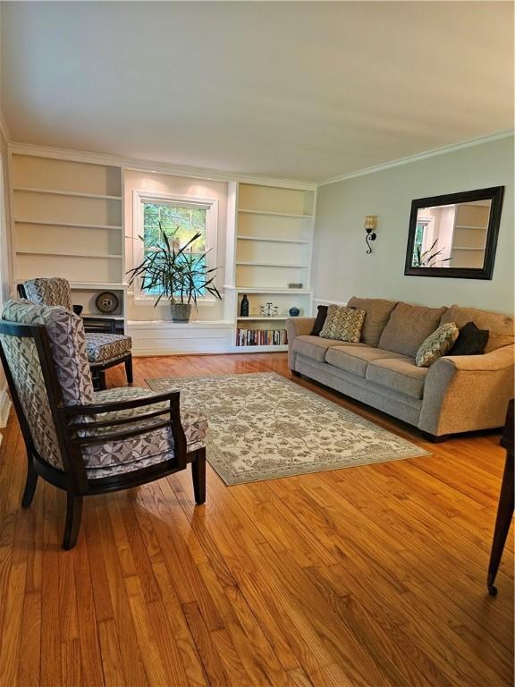 52 Woodland Dr, Big Flats, NY 14814 - living area with built in features, wood finished floors, and crown molding