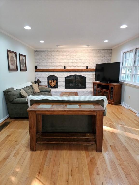 52 Woodland Dr, Big Flats, NY 14814 - living room with ornamental molding, light wood finished floors, baseboards, a brick fireplace, and recessed lighting