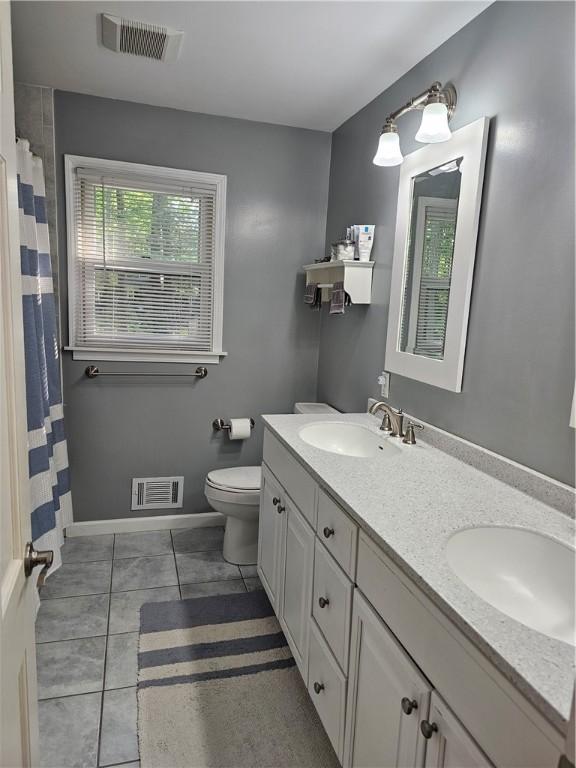 52 Woodland Dr, Big Flats, NY 14814 - full bath featuring double vanity, toilet, tile patterned flooring, baseboards, and a shower with curtain