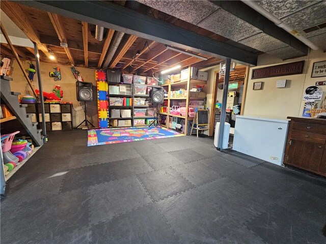 52 Woodland Dr, Big Flats, NY 14814 - unfinished basement with stairway, rubber floors, and refrigerator