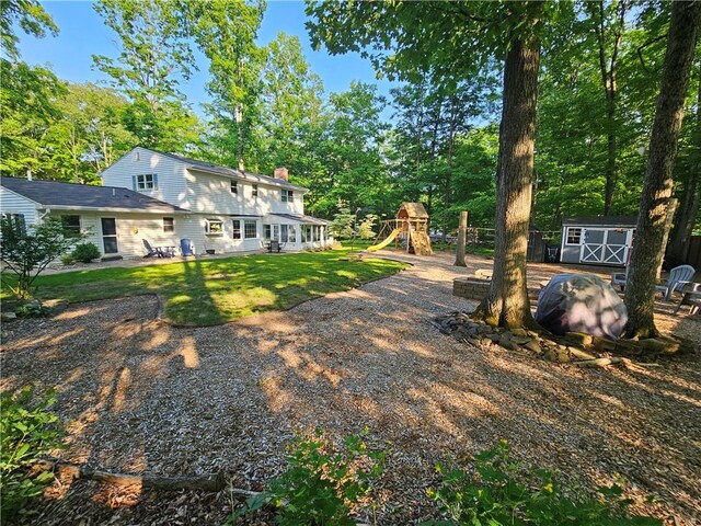 52 Woodland Dr, Big Flats, NY 14814 - view of grassy yard with a playground, a patio area, and view of scattered trees